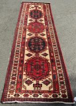 A north west Persian Heriz runner, with four hexagonal medallions with hooked borders, in