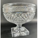 A large diamond cut glass punch bowl raised on a square base, 24cm diameter x 21cm high, together