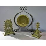 A brass dinner gong suspended in a wrought iron wire work frame, a brass Victorian desk calendar