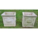 A pair of weathered composition stone planters of square form with classical raised relief detail,