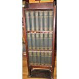 A bespoke oak bookcase containing, 18 volumes of Charles Dickens