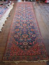 An old eastern wool runner, the central dark blue ground supporting abstract floral detail, within