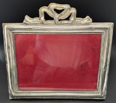 A pair of silver photo frames, both lacking glass, a third phot frame with a ribbon garland, (af)