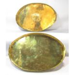 A pair of brass oval "Christmas trays" with holly and ivy decoration to the centre 55 cm x 36 cm