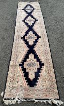 A Kasack style wool runner with a central row of medallions within a blue ground with geometric