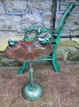 A small weathered cast iron bird bath of shell form with bird surmounts, raised on a central