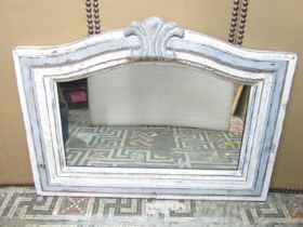 An overmantle mirror in a stepped and painted frame with arched outline, 83cm x 130cm