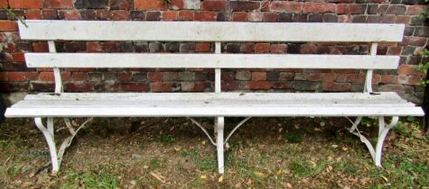 A vintage bench with painted wooden lathes, raised on sprung steel supports, 244cm long (af)