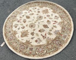 A circular Ziegler style carpet with a cream ground, interspersed with flowers, 200cm diameter