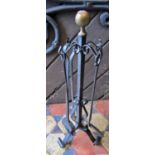 An ironwork fireside companion set with ball finial and scrolled supports, 68cm high