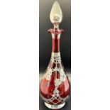 A late Victorian cranberry glass silver overlaid decanter decorated with garlands and flowers