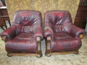 A pair of oak framed drawing room chairs with carved detail, maroon coloured upholstery