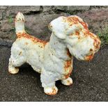 A small weathered cast iron garden ornament or door stop in the form of a standing terrier, 23cm