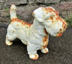 A small weathered cast iron garden ornament or door stop in the form of a standing terrier, 23cm