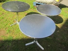 A pair of good quality stainless steel and cast alloy bistro tables with circular tops, 70cm