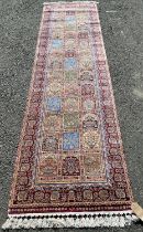 A middle eastern design machine made silk effect runner with multi floral panels, 305cm x 75cm