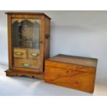 An early 20th century oak smokers cabinet with fitted interior and three drawers behind a single