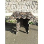 A Chinese square cut hardwood occasional table with deeply carved detail of wrythen dragons,