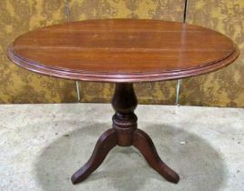 A late Victorian walnut oval tilt top table raised on a turned pillar and tripod, the top 97 cm x 70