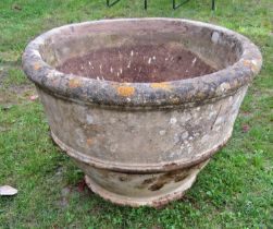 A large weathered composition stone garden planter of circular tapered ribbed form, 87cm diameter