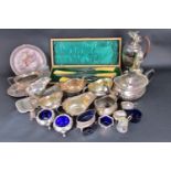 A silver plated selection of matching and near matching salt cellars, mustard pots etc, four sauce