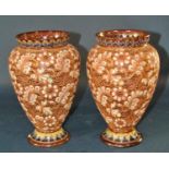 A pair of Doulton Lambeth oviform vases with pierced rims, and floral detail, three graduated