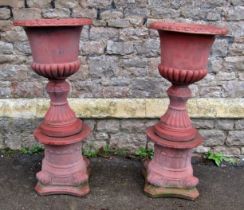 A pair of faux terracotta cast composition stone garden urns of classical design with flared rims,