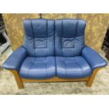 A Stressless Windsor high back two seat sofa in Paloma Oxford blue leather and beechwood together