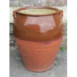 A terracotta storage jar, partially glazed with lug handles, 45cm high, together with six salt