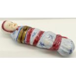 An unusual porcelain bodkin case, in the form of a foundling wrapped in swaddling, the hinged