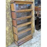 A Globe Wernicke & Co Ltd oak floorstanding five sectional library bookcase with 'up and over'
