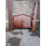 A 19th century mahogany bedstead with moulded outline raised on carved and scrolled supports (