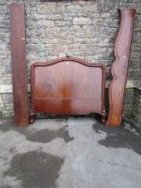 A 19th century mahogany bedstead with moulded outline raised on carved and scrolled supports (