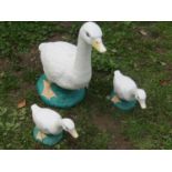 A family of three painted cast composition stone geese garden ornaments, the largest example 50cm