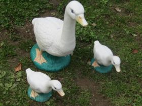 A family of three painted cast composition stone geese garden ornaments, the largest example 50cm