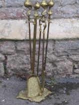 A cast brass fireside companion set with claw and ball pommels and scrolling tray base, (af)