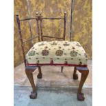 An Edwardian dressing stool with later re-upholstered rectangular seat raised on claw and ball
