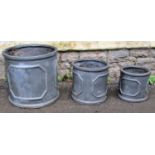 A graduated set of three weathered faux lead squat cylindrical planters the largest example 46cm