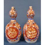 A pair of 19th century Imari gourd shaped vases with blue and red repeating floral decoration,