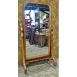 A Victorian pine cheval mirror with simple arched frame raised on chamfered swept scrolled and
