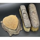 Three sets of silver backed hand mirrors, hair brushes and clothes brushes, (8) and a heart shaped