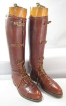 A pair of early 20th century brown leather gentlemen's riding boots with left and right wooden