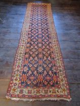 An old eastern carpet, the central field in ink blue with multi repeating abstract floral detail,