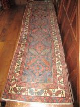 An old eastern wool runner with six medallion centre upon an ink coloured ground, within triple