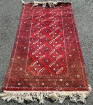 A Turkoman carpet with all over geometric pattern on a red ground, 200cm x 105cm