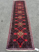 A north west Persian Senneh runner, with repeated central interlocking diamond medallions, in