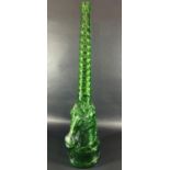 A tall green glass bottle in the form of a unicorn with spiral neck, 69.5cm high