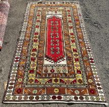 A Persian rug with a central rectangular panel and stylised flowers, 210 x 118cm approx