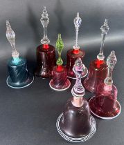 Seven Victorian Nailsea glass hand bells, 5 in a Cranberry colourway, including two with cotton