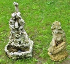 A weathered cast composition stone water feature in the form of a kneeling maiden holding a vase,